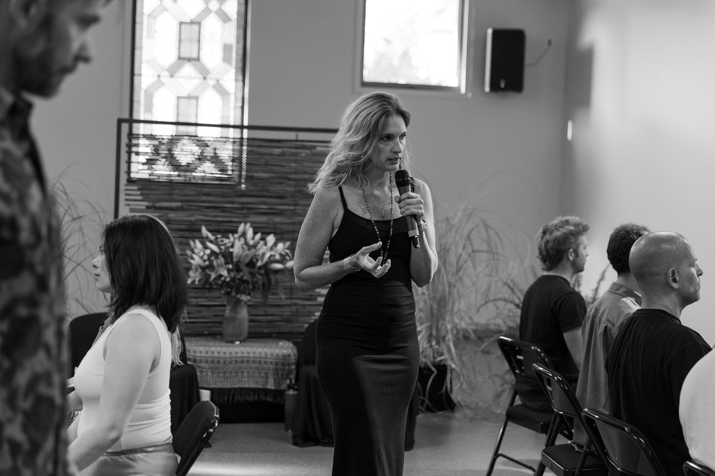 Option C: a person speaking in the room, hand on chest, black and white.