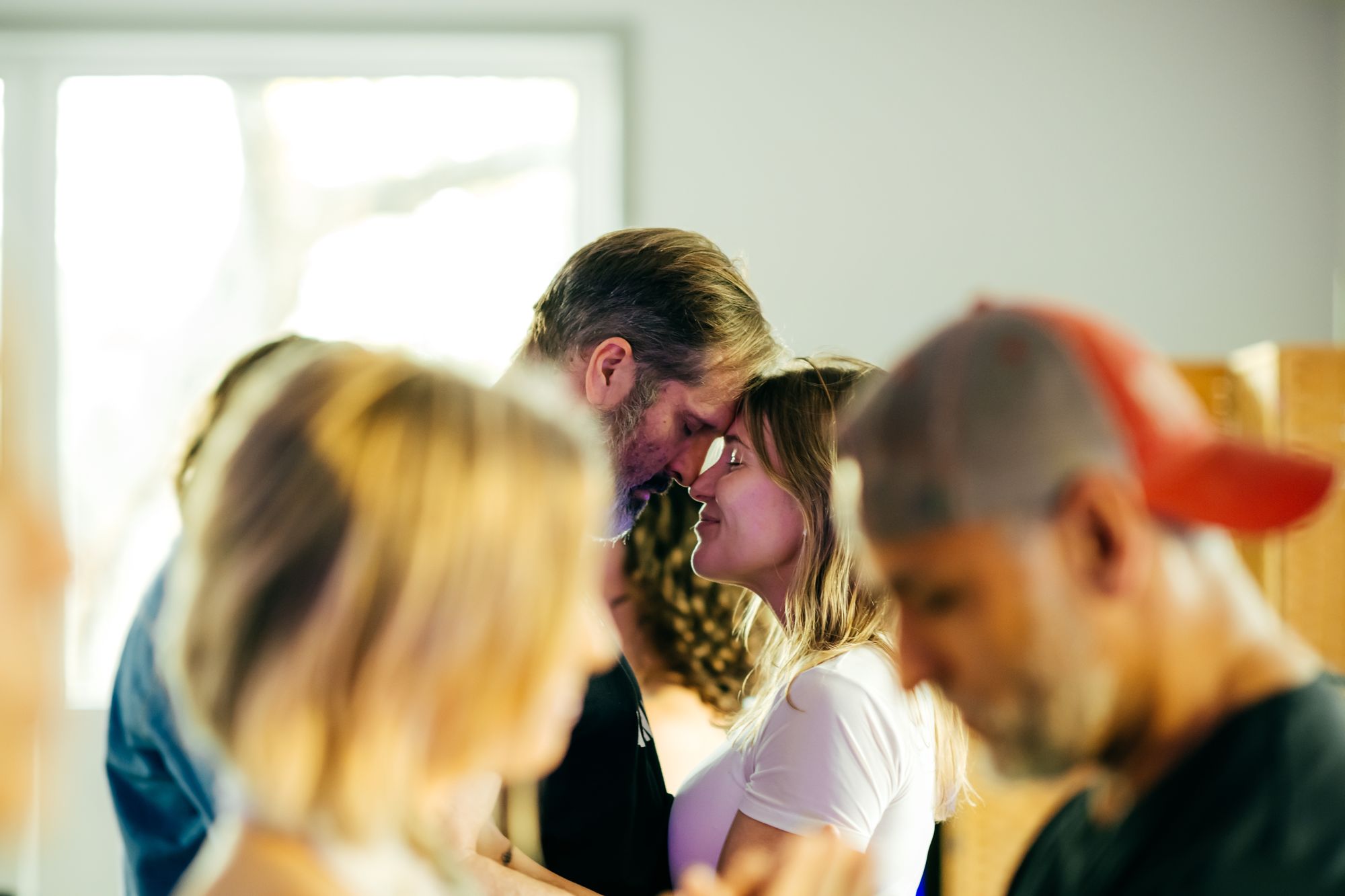 Participants standing close together in a bright, naturally lit workshop room.